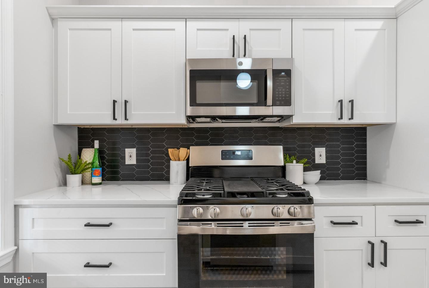 4818 Pimlico Road Baltimore, MD 21215 - Photo 6 of 18 a stove top oven sitting inside of a kitchen and granite counter tops