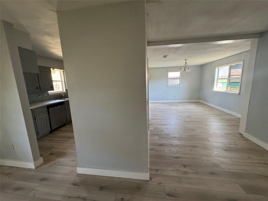 402 North Hughes Street Howe, TX 75459 - Photo 14 of 17 Hallway featuring light wood-type flooring and a chandelier