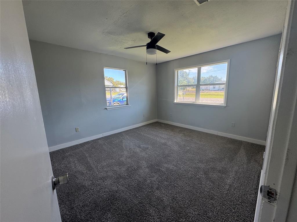 402 North Hughes Street Howe, TX 75459 - Photo 10 of 17 Unfurnished room with dark colored carpet, plenty of natural light, a textured ceiling, and ceiling fan