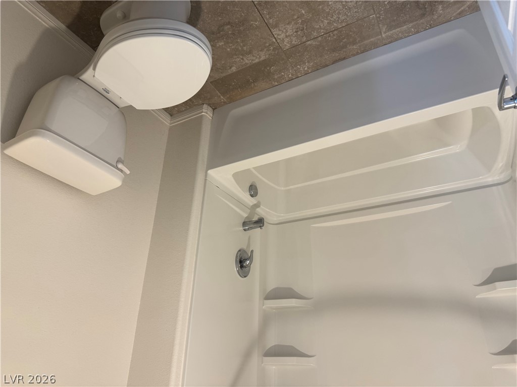 55 Canopus Ridge Way Las Vegas, NV 89183 - Photo 33 of 53 Tiled flooring pairs with a clean tub and shower combination in this functional bathroom.