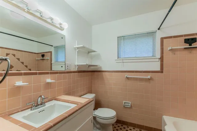 a bathroom with a sink a toilet and a mirror