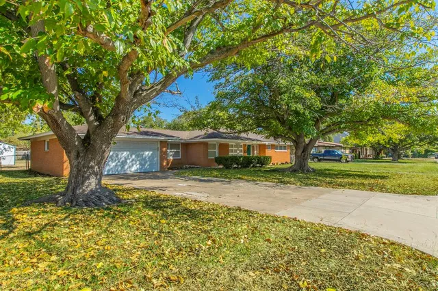 a house is sitting in middle of a yard