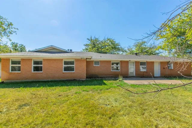 a view of a yard in front of a house with large tree