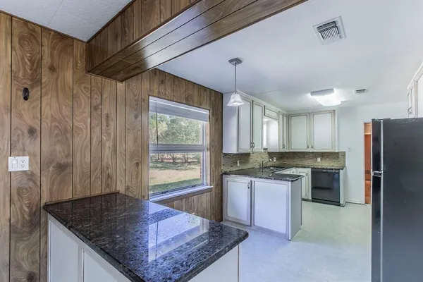 a kitchen with stainless steel appliances granite countertop a sink a stove and a refrigerator