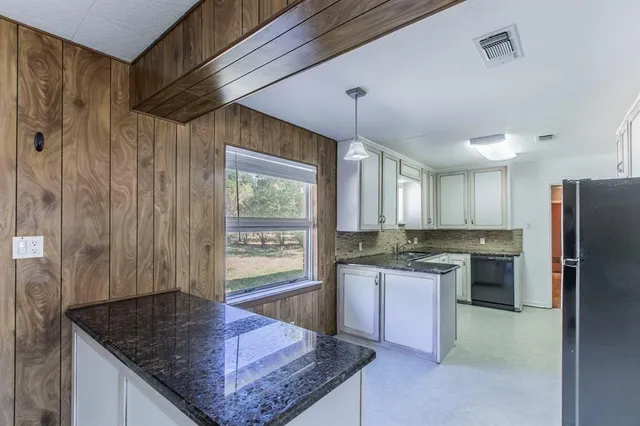 a kitchen with stainless steel appliances granite countertop a sink a stove and a refrigerator