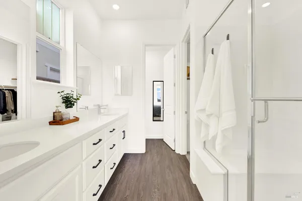 a bathroom with a granite countertop sink a mirror a vanity and a shower