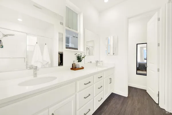 a bathroom with a sink double vanity granite tub shower and a mirror