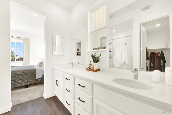 a bathroom with double vanity and a mirror