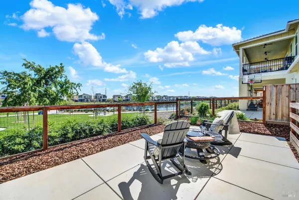 a roof deck with table and chairs potted plants with wooden floor