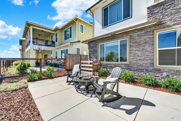 a view of a patio with a table chairs fire pit and a big yard