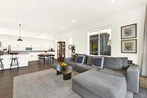 a living room with furniture and view of kitchen