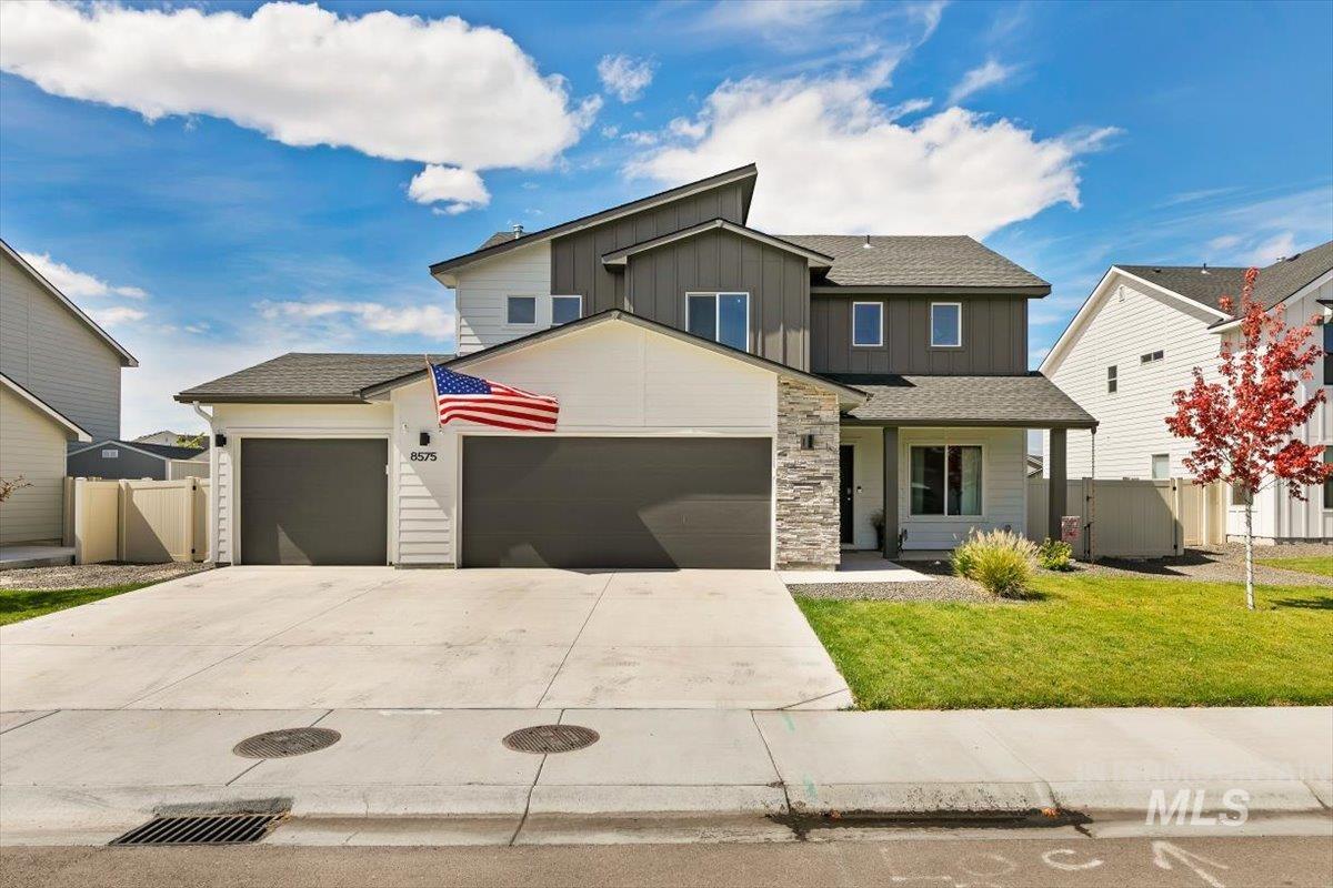 8575 South Foraker Way Kuna, ID 83634 - Photo 1 of 43 Modern exterior featuring a 3-car garage, stone veneer accents, and a covered entry