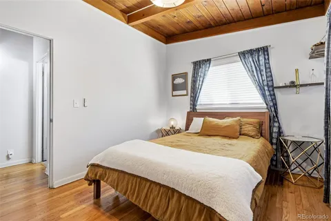 a bedroom with a bed and wooden floor