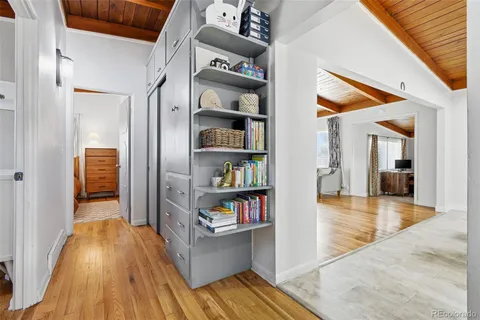 a view of hallway with wooden floor and furniture