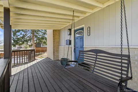 a view of a balcony with chairs and wooden floor
