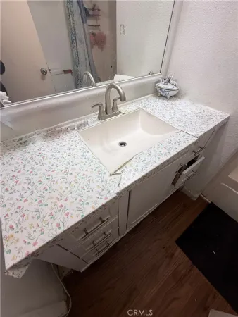 a bathroom with a granite countertop sink and a mirror