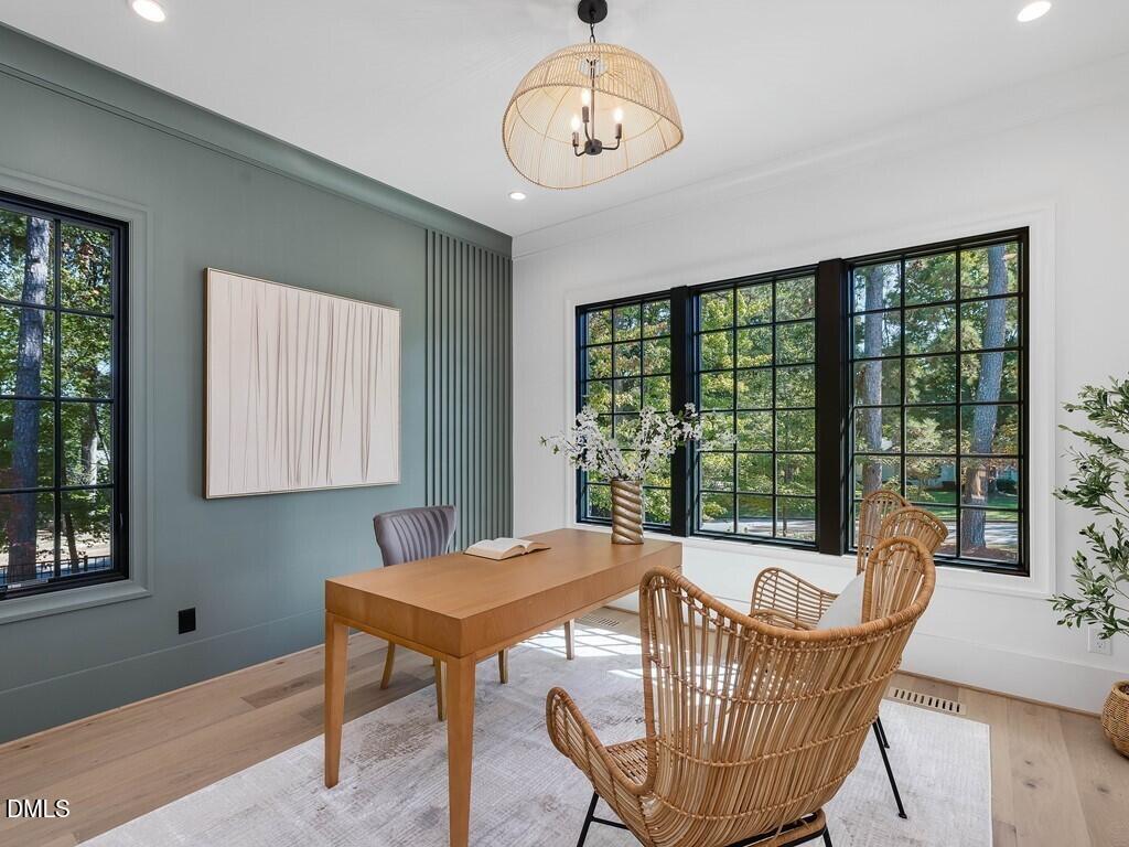 7013 Buckhead Drive Raleigh, NC 27615 - Photo 36 of 80 a dining room with furniture a chandelier and wooden floor