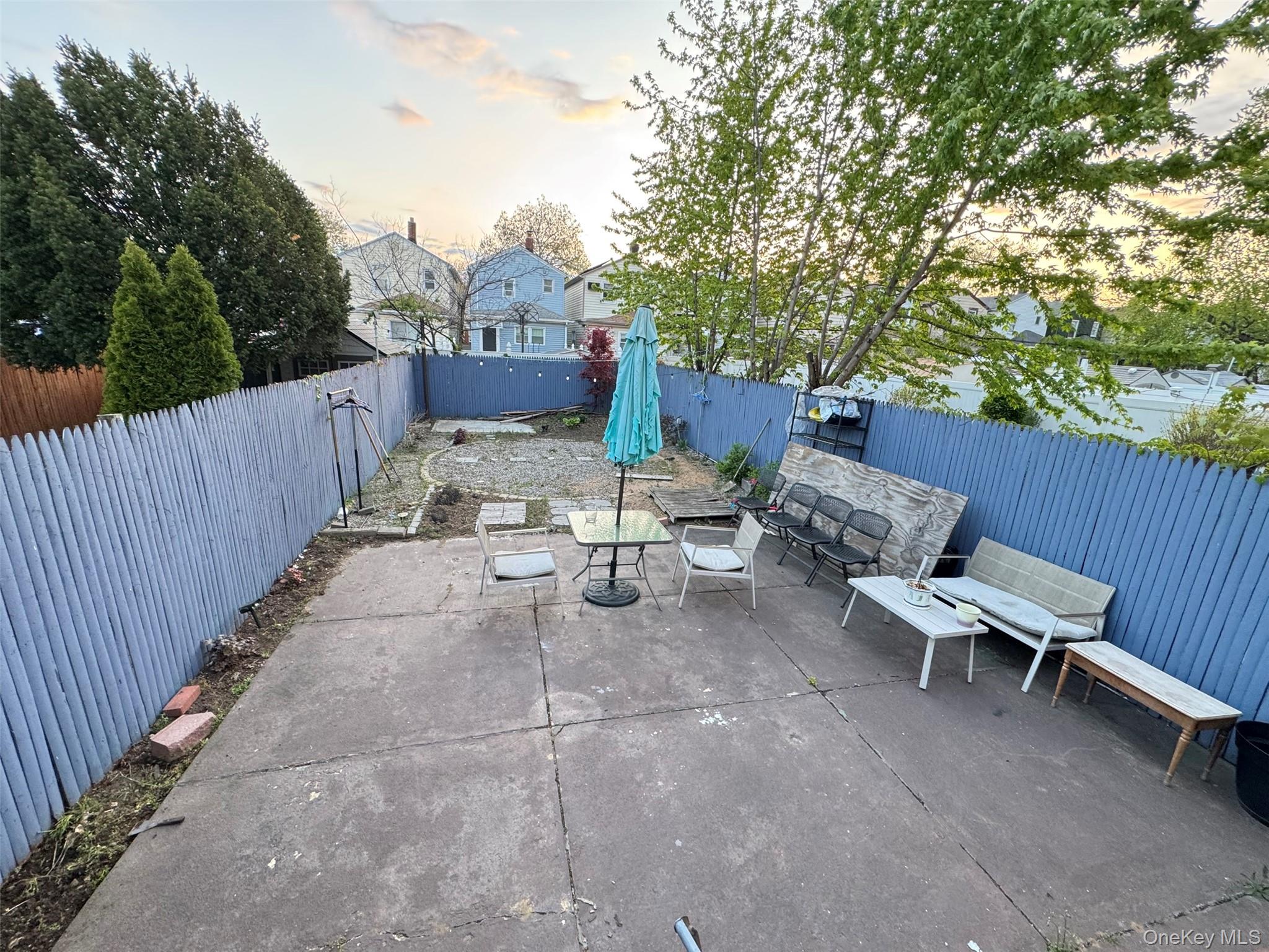 89-36 90th Street Queens, NY 11421 - Photo 17 of 17 a view of a patio with table and chairs with wooden fence and plants