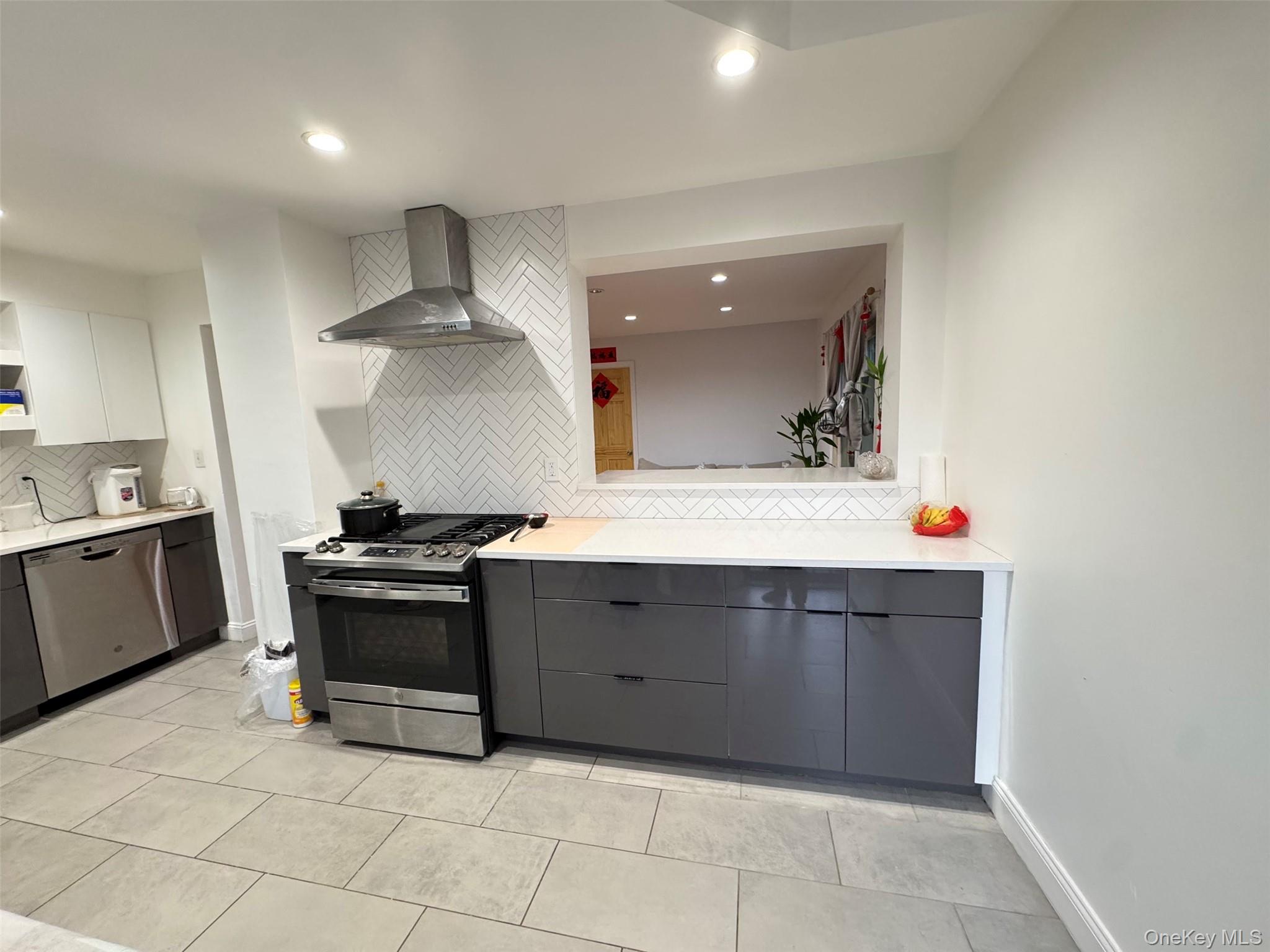 89-36 90th Street Queens, NY 11421 - Photo 5 of 17 a kitchen with stainless steel appliances a stove and more cabinets