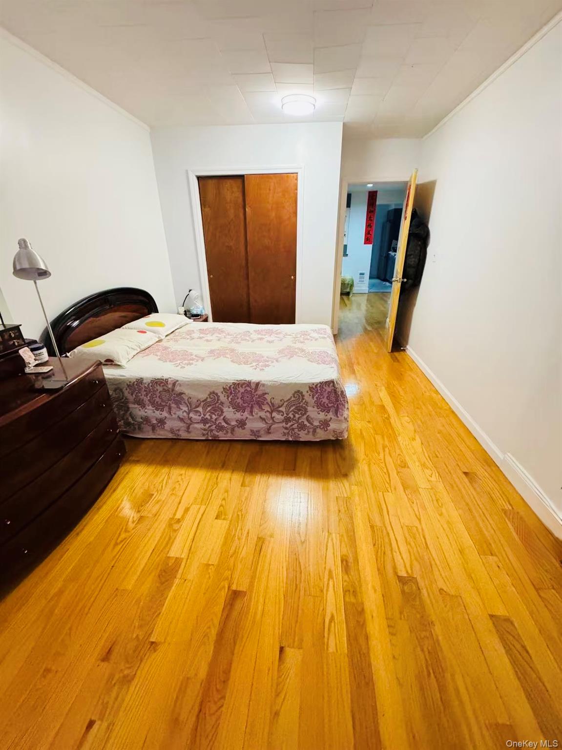 89-36 90th Street Queens, NY 11421 - Photo 7 of 17 a bedroom with a bed and wooden floor