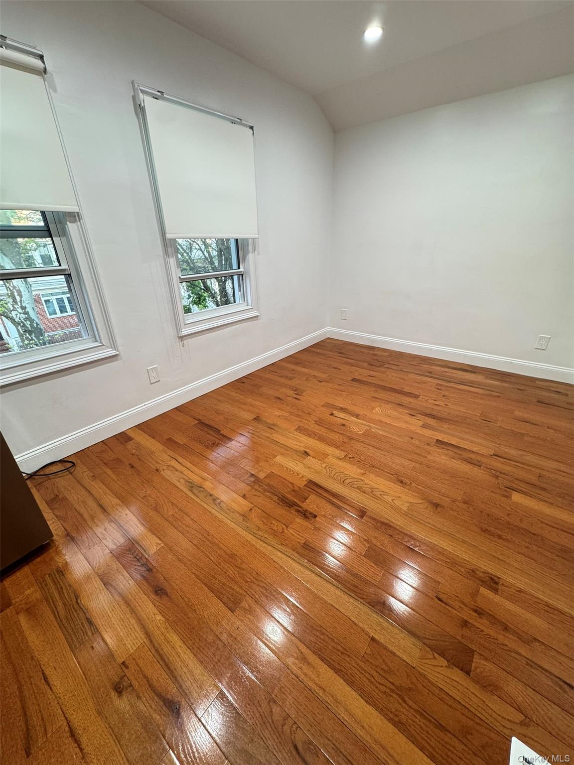 89-36 90th Street Queens, NY 11421 - Photo 10 of 17 an empty room with wooden floor and window