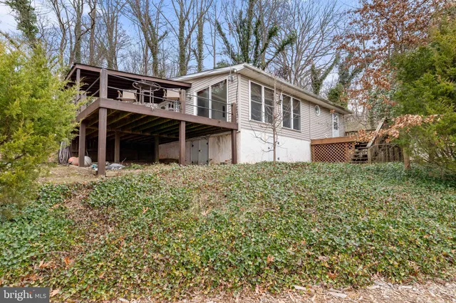 a view of a house with a large tree and wooden fence