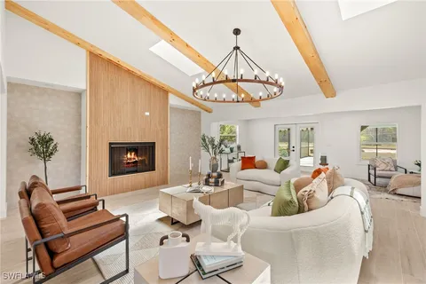 a living room with furniture a chandelier and a fireplace