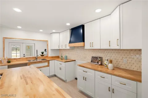 a kitchen with granite countertop a sink a stove and cabinets