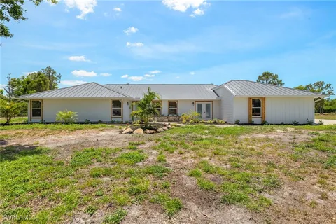 a front view of a house with a garden and yard