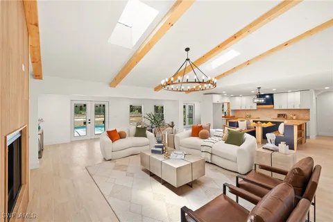 a living room with furniture a fireplace and a chandelier