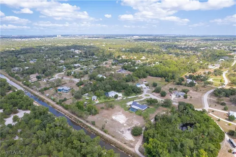 an aerial view of residential houses with outdoor space and trees