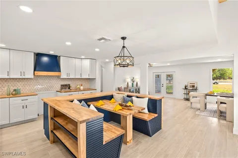 a view of a kitchen counter top space a sink wooden floor and living room view
