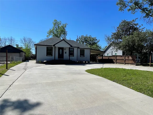 a front view of a house with a yard and trees