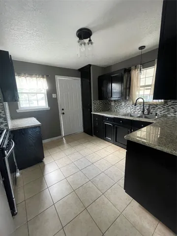 a kitchen with a sink a stove and cabinets