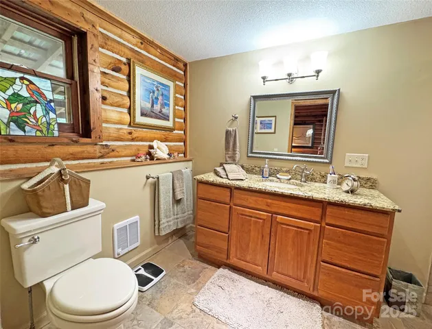a bathroom with a granite countertop sink mirror vanity and a shower
