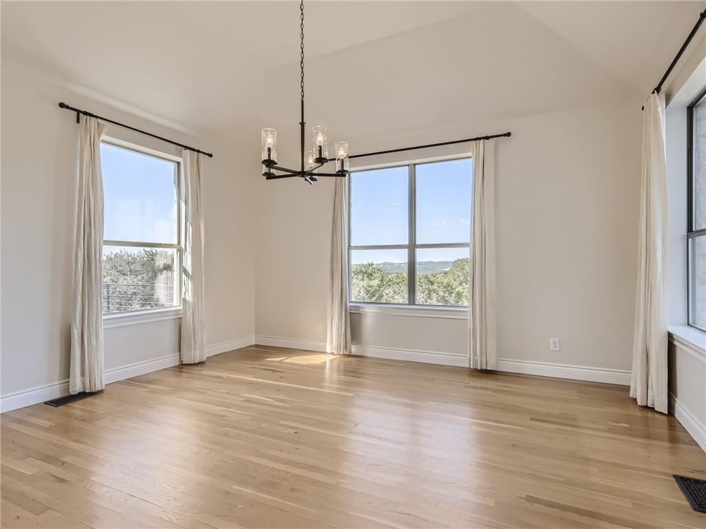 267 North Commons Ford Road Austin, TX 78733 - Photo 11 of 34 Unfurnished dining area with hanging lights, light wood-type flooring, and lofted ceiling