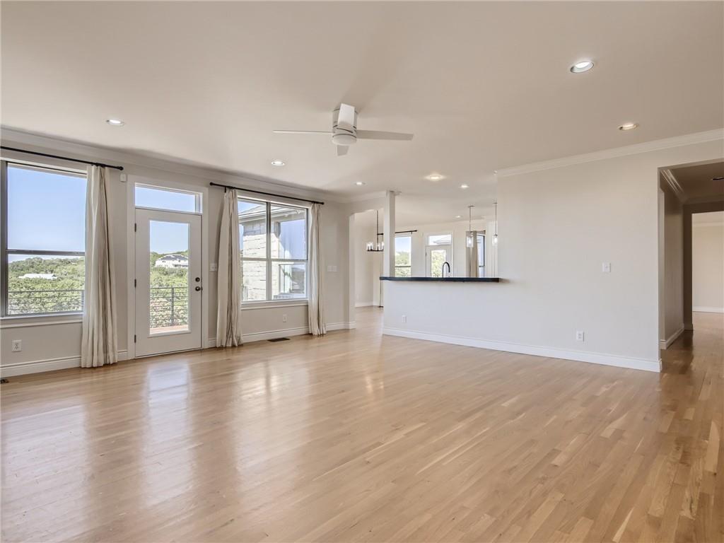 267 North Commons Ford Road Austin, TX 78733 - Photo 14 of 34 Unfurnished living room with ornamental molding, ceiling fan, light wood-style floors, and recessed lighting