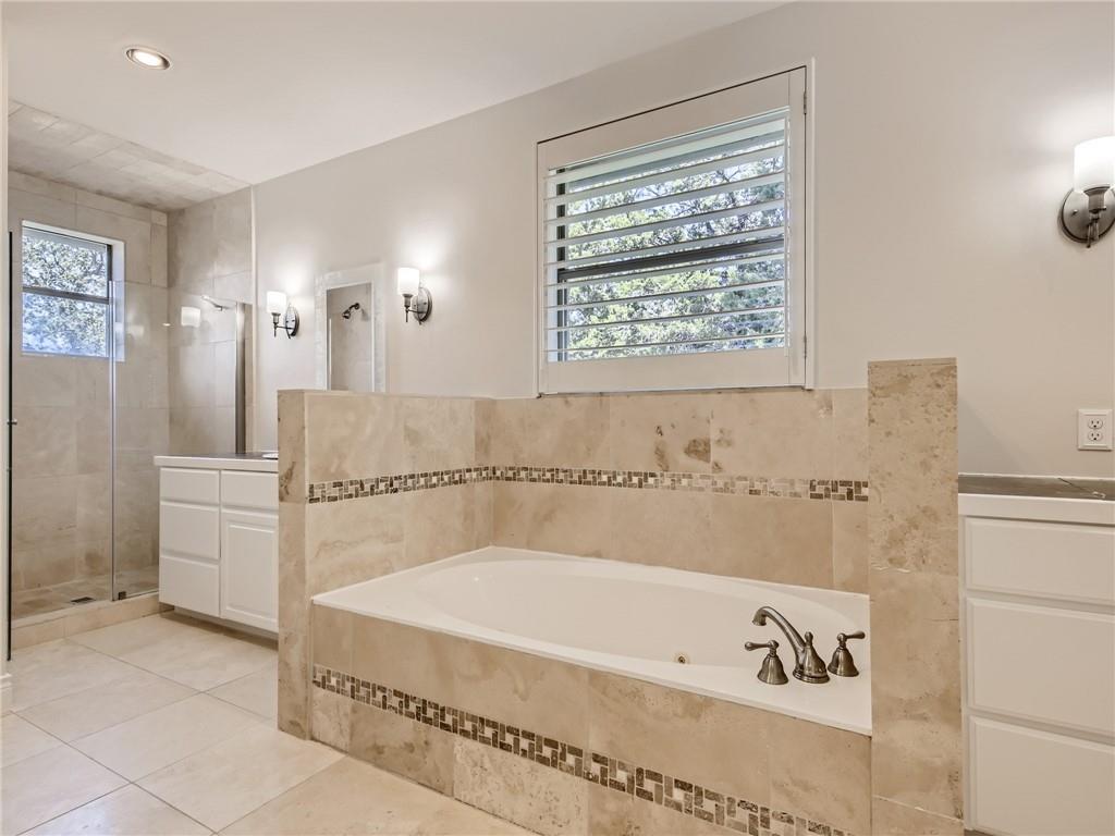 267 North Commons Ford Road Austin, TX 78733 - Photo 18 of 34 Full bath with a stall shower, a garden tub, light tile patterned floors, vanity, and recessed lighting