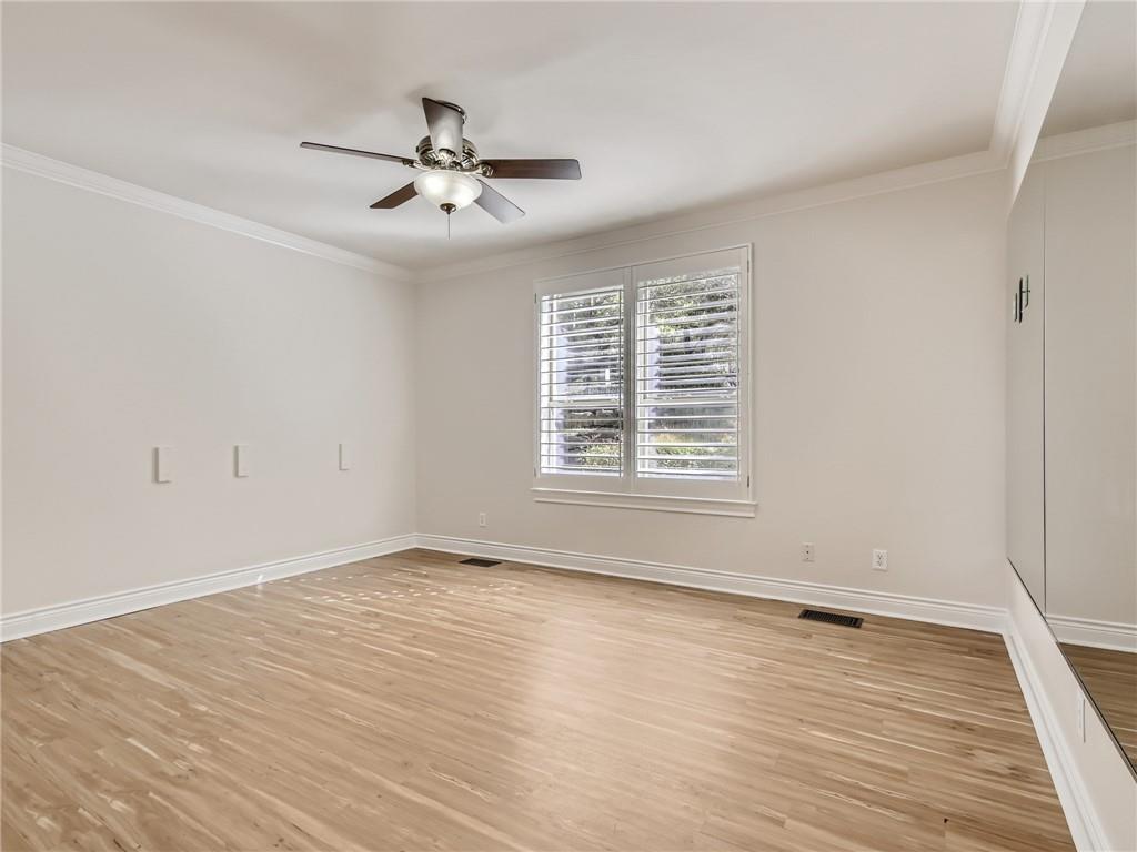 267 North Commons Ford Road Austin, TX 78733 - Photo 19 of 34 Unfurnished room with crown molding, light wood-type flooring, and a ceiling fan