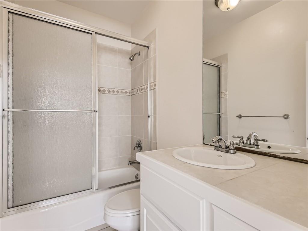 267 North Commons Ford Road Austin, TX 78733 - Photo 21 of 34 Bathroom featuring vanity and bath / shower combo with glass door