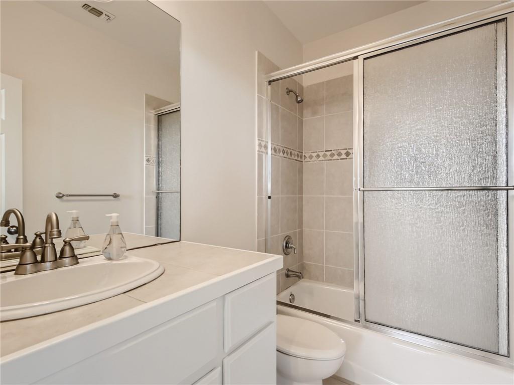 267 North Commons Ford Road Austin, TX 78733 - Photo 23 of 34 Full bath featuring vanity and bath / shower combo with glass door