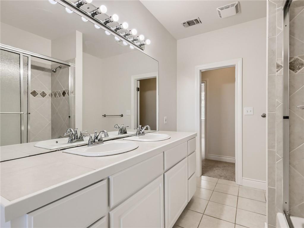 267 North Commons Ford Road Austin, TX 78733 - Photo 26 of 34 Bathroom with a stall shower, double vanity, and light tile patterned floors
