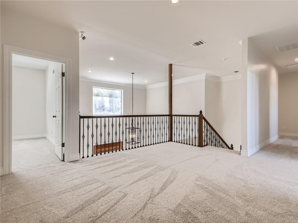 267 North Commons Ford Road Austin, TX 78733 - Photo 28 of 34 Carpeted spare room with hanging lights and crown molding
