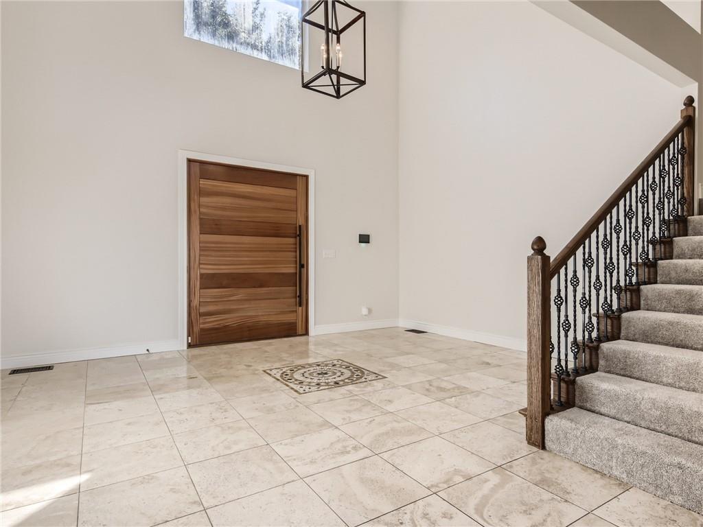 267 North Commons Ford Road Austin, TX 78733 - Photo 5 of 34 Foyer featuring hanging lights and a high ceiling