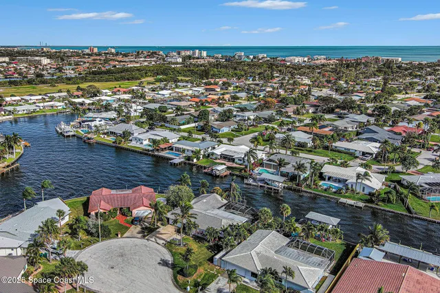 an aerial view of a city with lots of residential buildings ocean and mountain view in back