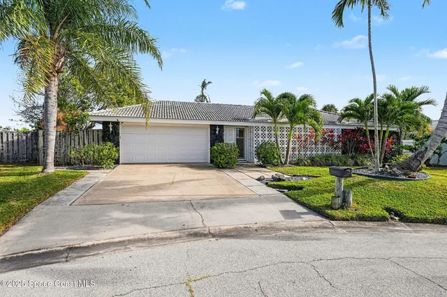 a front view of a house with a garden and yard