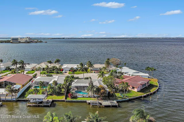 a view of an ocean with boats and trees in the background