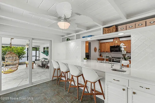 a kitchen with stainless steel appliances kitchen island granite countertop a table chairs and a chandelier