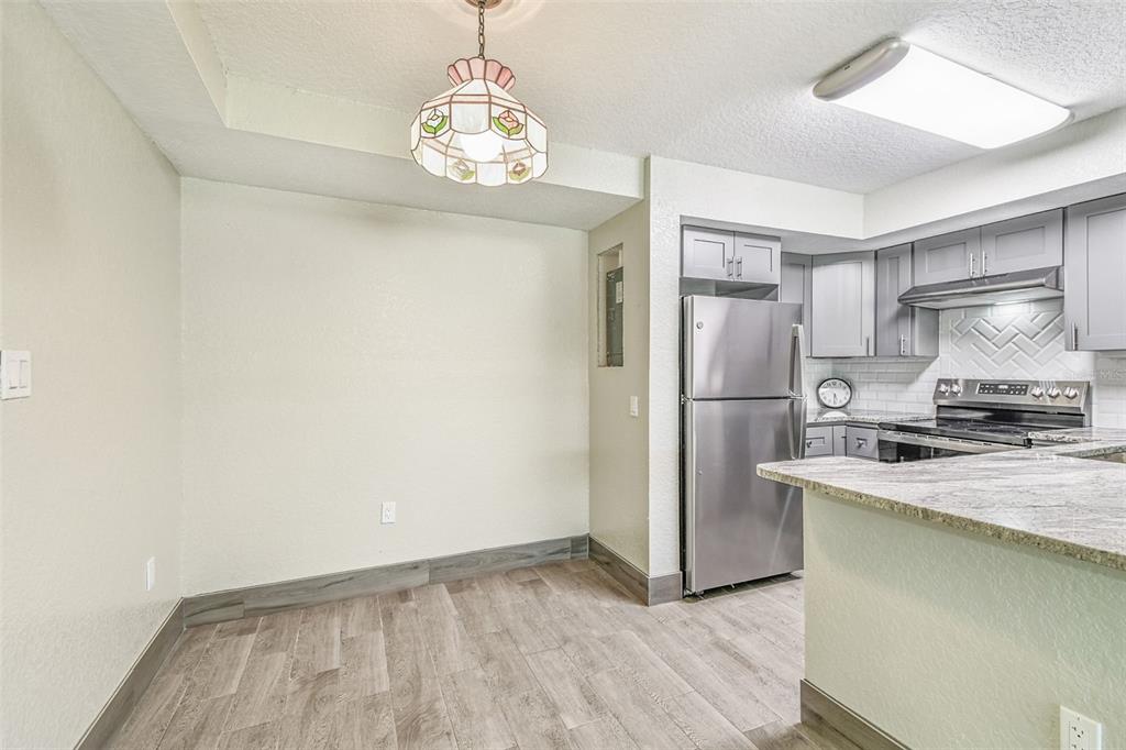 5111 Amulet Drive, Unit 104 New Port Richey, FL 34652 - Photo 17 of 74 a kitchen with stainless steel appliances granite countertop a refrigerator and a stove top oven