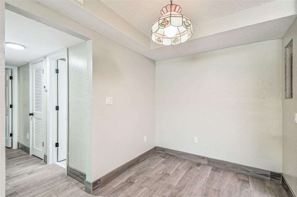 5111 Amulet Drive, Unit 104 New Port Richey, FL 34652 - Photo 18 of 74 an empty room with wooden floor and hallway